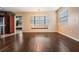 Spacious living room with gleaming wood floors, an adjacent kitchen, and sunlit window seating area at 12025 Environmental Dr # 5, New Port Richey, FL 34654