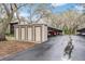 Assigned parking and storage in complex with beige storage units and covered parking, mature trees in background at 12025 Environmental Dr # 5, New Port Richey, FL 34654