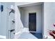 A welcoming entryway features a black front door, gray siding, and a 'welcome' doormat at 1291 Colt Creek Pl, Wesley Chapel, FL 33543
