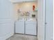 Bright laundry room features a washer, dryer, wire shelving, and tile floors at 1291 Colt Creek Pl, Wesley Chapel, FL 33543