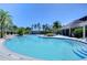 A sprawling swimming pool with zero entry and palm trees offers a tranquil escape with blue water at 1291 Colt Creek Pl, Wesley Chapel, FL 33543