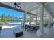 A covered poolside lounge area provides comfortable seating options with a bright blue pool view at 1291 Colt Creek Pl, Wesley Chapel, FL 33543