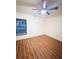 Empty bedroom featuring hardwood floors, a large window and a ceiling fan at 15013 Redcliff Dr, Tampa, FL 33625