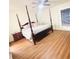 Bedroom featuring a four poster bed, side table, laminate wood flooring and a window with blinds at 15013 Redcliff Dr, Tampa, FL 33625