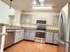 Modern kitchen with stainless-steel appliances, gray cabinets, and granite countertops for stylish meal prep at 15013 Redcliff Dr, Tampa, FL 33625