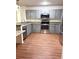 Updated kitchen featuring stainless steel appliances, gray cabinets, granite countertops, and hardwood floors at 15013 Redcliff Dr, Tampa, FL 33625