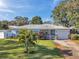 Charming single-story home with a well-manicured lawn, palm tree, and welcoming front porch at 2021 58Th S St, Gulfport, FL 33707