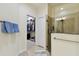 Spacious bathroom featuring an open door to a closet, glass shower, and towel rack adding convenience and style at 2253 Oakley Green Dr # 26, Sun City Center, FL 33573