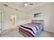 Comfortable bedroom featuring a ceiling fan, tray ceiling, and access to the ensuite bathroom at 2253 Oakley Green Dr # 26, Sun City Center, FL 33573