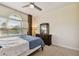 Bedroom featuring a bed with blue comforter, ceiling fan, and window with blinds and curtains at 2253 Oakley Green Dr # 26, Sun City Center, FL 33573