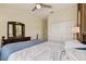 Bedroom featuring a bed with blue comforter, ceiling fan, closet, and dresser at 2253 Oakley Green Dr # 26, Sun City Center, FL 33573