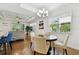 Bright dining area featuring a modern chandelier, hardwood floors, and open access to the living room at 2253 Oakley Green Dr # 26, Sun City Center, FL 33573