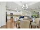 Bright dining area featuring a modern chandelier, hardwood floors, and open access to the kitchen at 2253 Oakley Green Dr # 26, Sun City Center, FL 33573