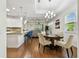 Bright dining area featuring a modern chandelier, hardwood floors, and open access to the living room and kitchen at 2253 Oakley Green Dr # 26, Sun City Center, FL 33573