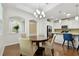 Bright dining area featuring a modern chandelier, hardwood floors, and open access to the kitchen at 2253 Oakley Green Dr # 26, Sun City Center, FL 33573