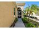 Close-up of the inviting front door with glass detailing, complemented by tropical landscaping at 2253 Oakley Green Dr # 26, Sun City Center, FL 33573