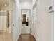 Bright hallway with wood floors, white walls, and doorways to a bathroom and bedroom at 2253 Oakley Green Dr # 26, Sun City Center, FL 33573
