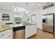 Bright kitchen featuring white cabinetry, stainless steel appliances, granite countertops, and adjacent dining area at 2253 Oakley Green Dr # 26, Sun City Center, FL 33573