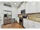 Well-lit kitchen featuring stainless steel appliances, granite countertops, white cabinetry, and hardwood floors at 2253 Oakley Green Dr # 26, Sun City Center, FL 33573