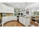 Spacious kitchen featuring white cabinets, stainless appliances, granite counters and an island; seamlessly connects to dining area at 2253 Oakley Green Dr # 26, Sun City Center, FL 33573