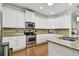 Bright kitchen features white cabinetry, stainless steel appliances, and granite countertops, perfect for modern living at 2253 Oakley Green Dr # 26, Sun City Center, FL 33573