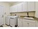 Laundry room with granite countertops, stainless steel sink, and white washer and dryer at 2253 Oakley Green Dr # 26, Sun City Center, FL 33573