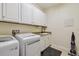 Clean laundry room with a modern washer and dryer, granite countertops, and white cabinetry at 2253 Oakley Green Dr # 26, Sun City Center, FL 33573