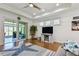 Bright living room with hardwood floors, ceiling fan, and sliding doors to screened-in patio with water view at 2253 Oakley Green Dr # 26, Sun City Center, FL 33573