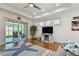Bright living room with hardwood floors, ceiling fan, and sliding doors to screened-in patio with water view at 2253 Oakley Green Dr # 26, Sun City Center, FL 33573