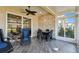 Comfortable sunroom with tile floors, brick accent wall, ceiling fan, and view into the living room at 2253 Oakley Green Dr # 26, Sun City Center, FL 33573