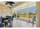 Bright sunroom features large windows with beautiful lake views, ceiling fan, and a dining area at 2253 Oakley Green Dr # 26, Sun City Center, FL 33573
