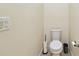 Clean and simple toilet area in the bathroom featuring a toilet, a holder, and a sleek trash can at 2253 Oakley Green Dr # 26, Sun City Center, FL 33573
