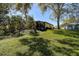 Manicured backyard with towering trees and lush lawn at 2457 Orangepointe Ave, Palm Harbor, FL 34683