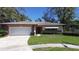 Charming single-story home featuring a well-maintained lawn and attached two-car garage at 2457 Orangepointe Ave, Palm Harbor, FL 34683