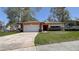 A charming one-story home with a two-car garage and a neatly manicured lawn at 2457 Orangepointe Ave, Palm Harbor, FL 34683