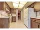 Bright kitchen featuring wood cabinets, white appliances, and a tiled floor, perfect for cooking and entertaining at 2457 Orangepointe Ave, Palm Harbor, FL 34683