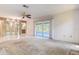 Spacious open-concept living room with a carpet area and sliding glass doors to the sunroom at 2457 Orangepointe Ave, Palm Harbor, FL 34683