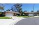 A street view showing a charming single-story home with a well-maintained lawn and a two-car garage at 2457 Orangepointe Ave, Palm Harbor, FL 34683