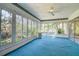 Bright sunroom with floor-to-ceiling windows, a ceiling fan, and lush greenery just outside, creating a peaceful retreat at 2457 Orangepointe Ave, Palm Harbor, FL 34683