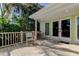 Charming patio area with light wood decking, french doors and mature tropical landscaping at 2605 Pass A Grille Way, St Pete Beach, FL 33706