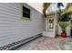 Side of home features white siding, bright trim, and cozy outdoor patio area at 2605 Pass A Grille Way, St Pete Beach, FL 33706