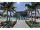 Resort-style pool area with palm trees, ample lounge chairs, and clear blue water at Highland Lakes at 2873 Doone Cir, Palm Harbor, FL 34684