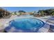Relaxing hot tub with nearby pool, lounge chairs, and umbrellas at Highland Lakes at 2873 Doone Cir, Palm Harbor, FL 34684