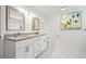 Bright bathroom featuring double vanity, white cabinets, and granite countertops at 292 42Nd Ave, St Pete Beach, FL 33706