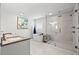 Bright bathroom featuring double vanity, a soaking tub, and a glass-enclosed shower at 292 42Nd Ave, St Pete Beach, FL 33706