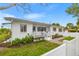 Charming single-story home with a well-maintained front yard, white picket fence, and inviting porch at 292 42Nd Ave, St Pete Beach, FL 33706