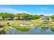 Aerial view of Highland Lakes community, with pond, signage, golf course, and mature trees at 3210 Mcmath Dr, Palm Harbor, FL 34684