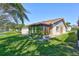 Back exterior view shows the siding, sunroom, and well-manicured lawn at 3210 Mcmath Dr, Palm Harbor, FL 34684