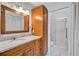 Bathroom with granite countertops, wood cabinets, and a glass-enclosed shower at 3210 Mcmath Dr, Palm Harbor, FL 34684