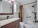 Bathroom with dark wood vanity, updated fixtures, and shower-tub combination at 3210 Mcmath Dr, Palm Harbor, FL 34684